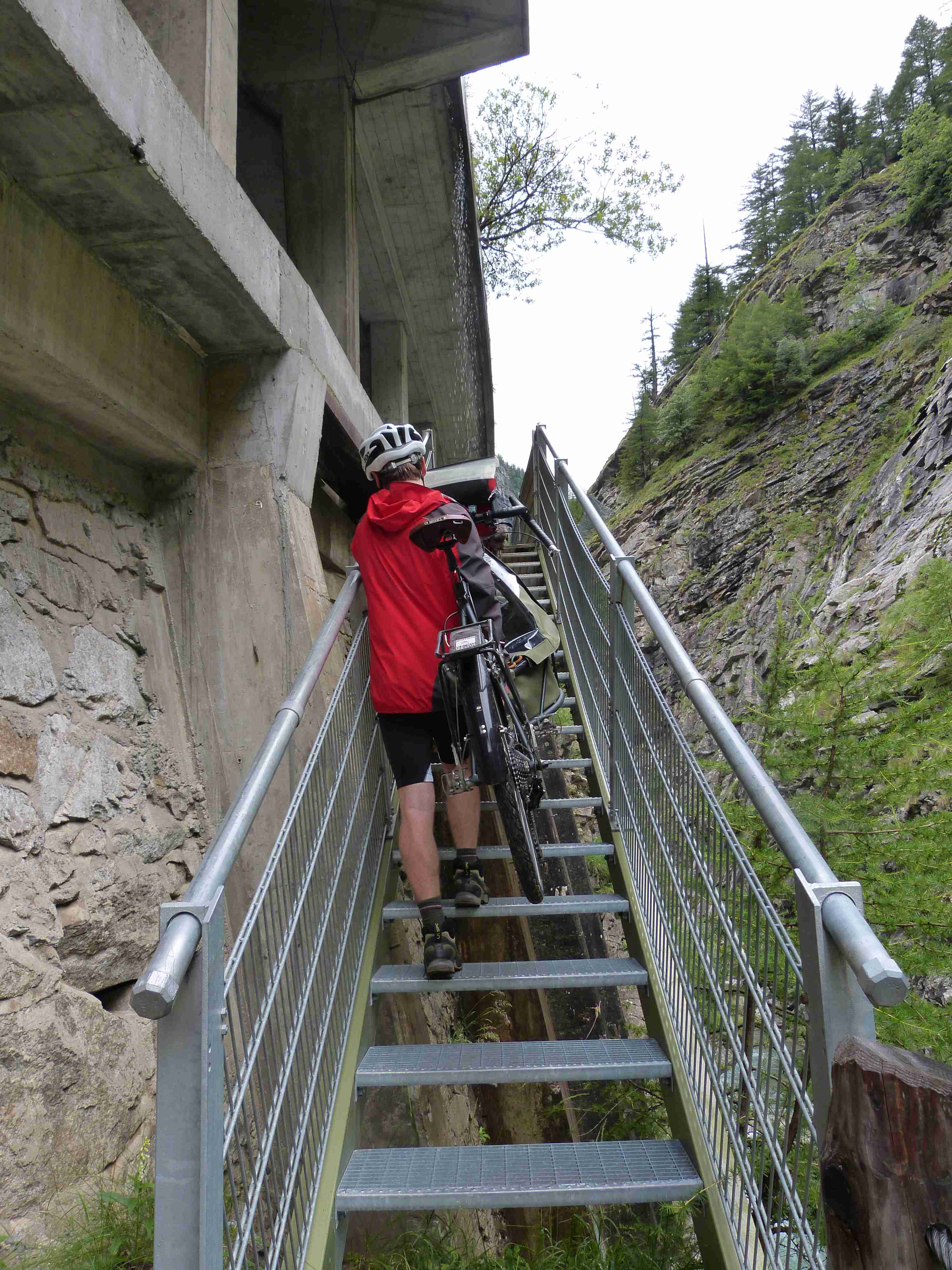 Daniel carrying the cargo bike up the stairs on the footpath towards Simplon pass